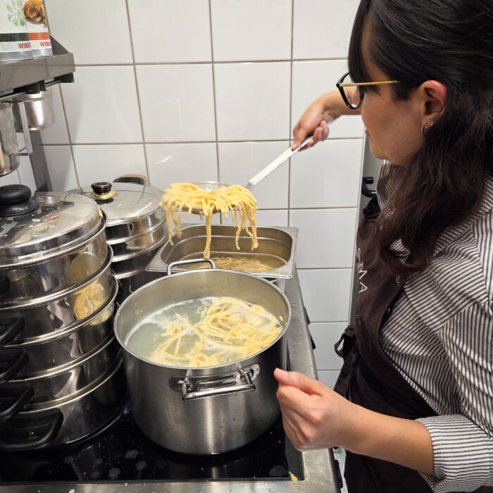 SPÄH Mitarbeiterin schöpft die Spätzle aus dem Wasser